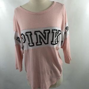 A pink and white long sleeve with black lettering